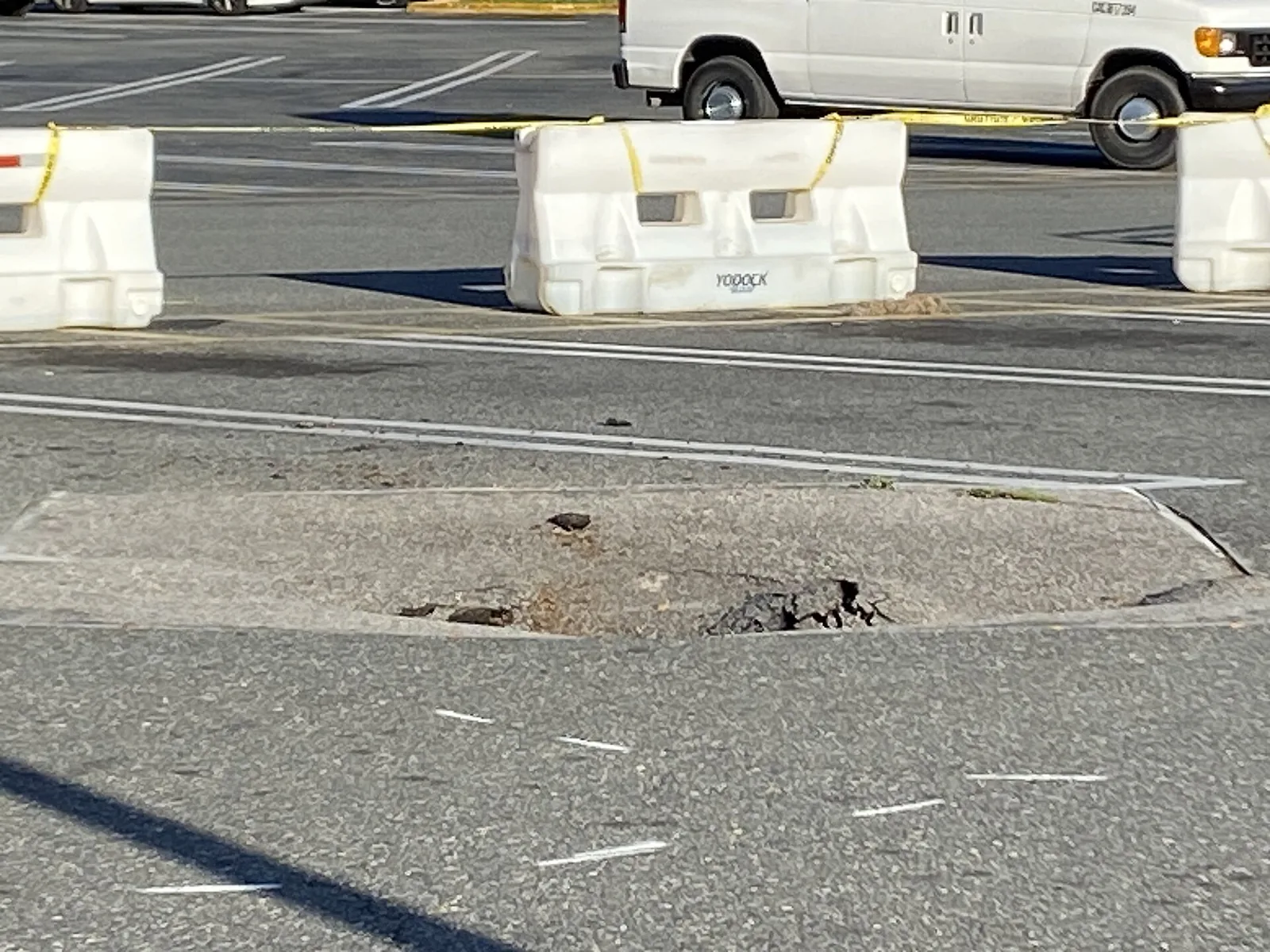 A sinkhole that has opened again in a patched car park surface